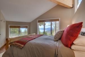 a bedroom with a bed and two windows at Tahoe Point of View - Amazing Lake Views at this 4BR w Hot Tub, Sauna, Near Skiing in Tahoe City