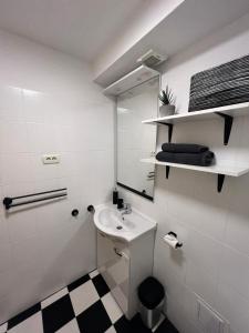 ein weißes Badezimmer mit einem Waschbecken und einem Spiegel in der Unterkunft Soul Apartments in Izola