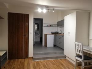 eine Küche mit einer Tür, die sich zu einer Küche mit einem Tisch öffnet in der Unterkunft Noclegi Pod Lasem in Krakau