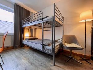 1 dormitorio con 2 literas y 1 silla en WinWin im Westen en Bielefeld