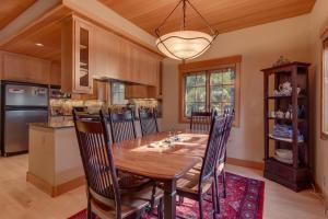 a dining room with a wooden table and a kitchen at Tahoe Time on North Shore - 4 BR Cabin w Private Hot Tub, Pet Friendly, Walk to Dining in Tahoe Vista
