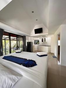 um grande quarto branco com uma grande cama branca em Scenery Sunrise em Chaweng Noi Beach