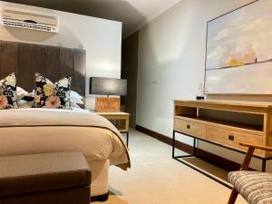 a bedroom with a large bed and a dresser at Calais Guest House in Franschhoek +50 photos