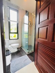 a bathroom with a shower and a toilet and a glass door at Scenery Sunrise in Chaweng Noi Beach