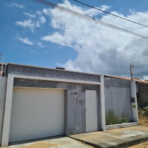 a garage with two white garage doors on it at Casa Camocim in Camocim