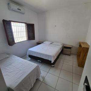 1 dormitorio con 2 camas y ventana en Casa Camocim en Camocim