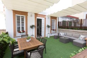 een patio met een tafel en stoelen en een bank bij Family Century House with terrace and parking in Valencia
