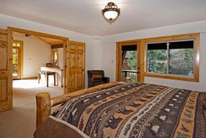 um quarto com uma cama, uma secretária e janelas em Valley View at Palisades -4 BR w Mountain Views, Pet-Friendly, and Close to Village em Olympic Valley