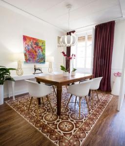 a dining room with a table and chairs on a rug at Family Century House with terrace and parking in Valencia