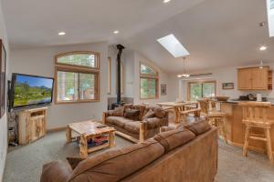 a living room with a large couch and a kitchen at Tahoma Charm on West Shore - Beautiful Open Concept 3 BR w Private Hot Tub in Tahoma