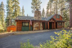 eine Blockhütte mit einem Kamin und einer Auffahrt in der Unterkunft Ward Creek Retreat - Cozy Old Tahoe Cabin w Short Drive to Ski Resorts Pet Friendly in Tahoe City