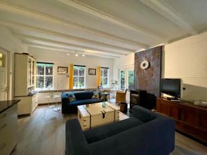 uma sala de estar com dois sofás e uma televisão em Landgoed De Heezeberg em Diever