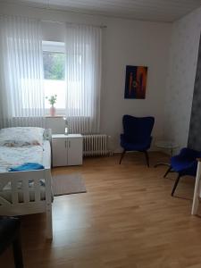 um quarto com uma cama, uma cadeira e uma janela em Gästehaus Atrico Haus 7 em Neubörger