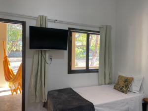 una camera con letto e TV a schermo piatto a parete di Villa Encantos do Paraíso 50mts da lagoa a Jijoca de Jericoacoara