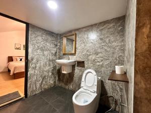 a bathroom with a toilet and a sink at Jungle guest house in Mae Hong Son