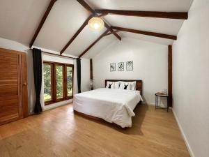 a bedroom with a white bed and a large window at Jungle guest house in Mae Hong Son