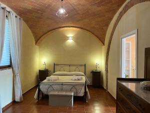 a bedroom with a bed and a brick wall at Podere La Selva in Rapolano Terme