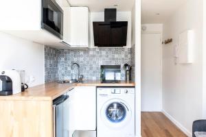 a kitchen with a washer and dryer in it at Montmartre Aparts 2 individual studios in Paris