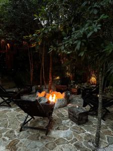 a fire pit in a yard with a chair at Hotel Bardo - Adults Only in Tulum