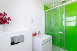 ein grünes Bad mit einem Waschbecken und einer Dusche in der Unterkunft Stunning S/Wimbledon Flat w/parking in London, Uk in London