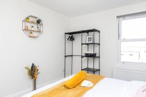 a white bedroom with a bed with a yellow blanket at Stunning S/Wimbledon Flat w/parking in London, Uk in London