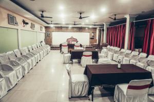 a banquet hall with tables and white chairs at The Avantika Hotel & Woodland Restaurant in Gorakhpur