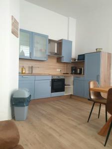 a kitchen with blue cabinets and a table and chairs at Zur Altstadt in Plauen