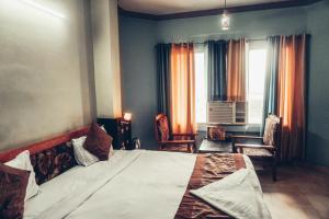 a bedroom with a large bed and a window at The Avantika Hotel & Woodland Restaurant in Gorakhpur