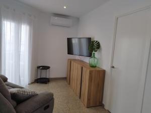 - un salon avec une télévision à écran plat sur une armoire en bois dans l'établissement Apartament IXA-2, à Manresa