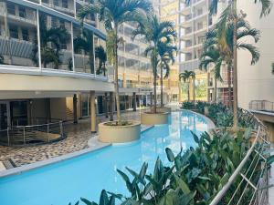 an indoor pool with palm trees in a building at The Sails One Bedroom Apartment in Durban