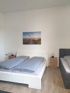 a white bed in a room with a couch at Zur Altstadt in Plauen
