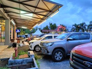 a parking lot with cars parked in front of a store at Hotel Nawar in Pasir Mas