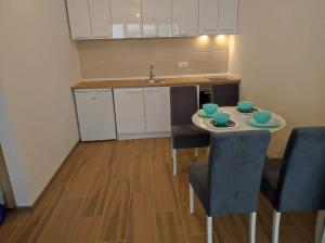 a small kitchen with a table and chairs and a sink at Diego - Ravna planina in Pale