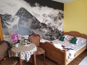 a bedroom with a bed and a table with chairs at Bębenkowie in Białka Tatrzańska
