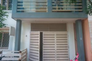 een klein huis met een deur en een balkon bij Kadal Homestay in Pondicherry