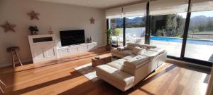 sala de estar con sofá, TV y piscina en Ikasmendi en Rentería
