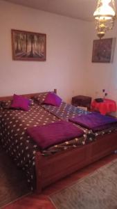 a bedroom with a large bed with purple pillows at Kuca za odmor Lucija in Zagreb