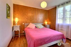 een slaapkamer met een roze bed en een raam bij Gite de la Vialle in Lamastre