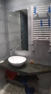 a bathroom with a sink and a mirror at Apartments Dimitra in Paralia Dionysiou