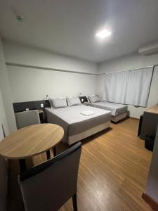 a room with two beds and a table in it at Hoteis Cattoni in Lages