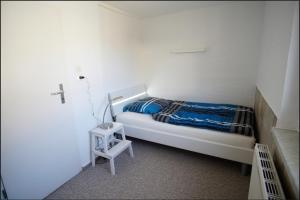 a small bedroom with a bed and a night stand at Haus am See in Schwielowsee