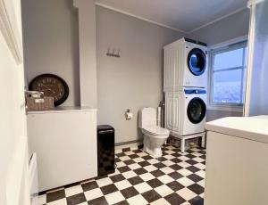 y baño con aseo y lavadora. en Koselig leilighet med fantastisk utsikt, en Tromsø