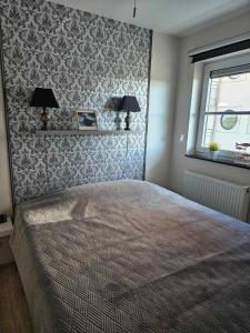 a bedroom with a bed with a patterned wall at Sailors Beach VI Villa Jalina verwarmd zwembad in het hoogseizoen in Nieuwpoort