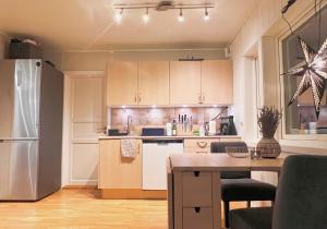 Una cocina con un refrigerador blanco y una mesa. en Koselig leilighet med fantastisk utsikt, en Tromsø 14 fotos más