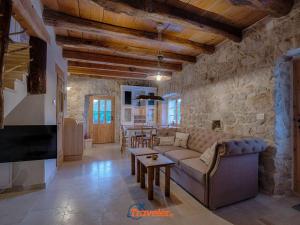 un soggiorno con un divano e una TV di Beautiful stone villa with swimming pool, sauna and large garden by Traveler tourist agency Krk ID 2225 a Gabonjin