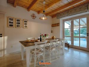 una cucina con tavolo con sedie e sala da pranzo di Beautiful stone villa with swimming pool, sauna and large garden by Traveler tourist agency Krk ID 2225 a Gabonjin