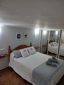 ein Schlafzimmer mit einem großen weißen Bett mit Spiegeln in der Unterkunft Puerto Sol Playa in Fuengirola
