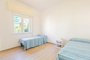 een slaapkamer met 2 bedden en een raam bij Appartamento vista mare di Marco in Spotorno