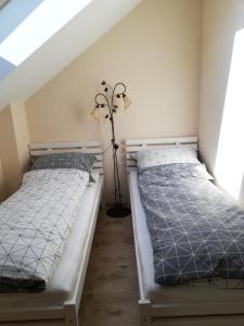 two twin beds in a room with a attic at Noclegi Pod Lasem in Krakow