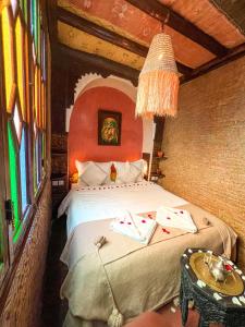 a bedroom with a bed and a table in a room at Riad Elli Marrakech in Marrakesh